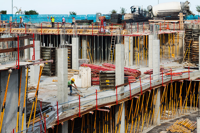 active construction site with scaffolding, temporary lighting and stored building materials