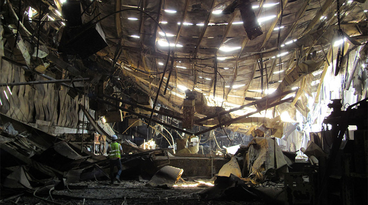 forensic engineer conducting a site inspection at a warehouse fire scene