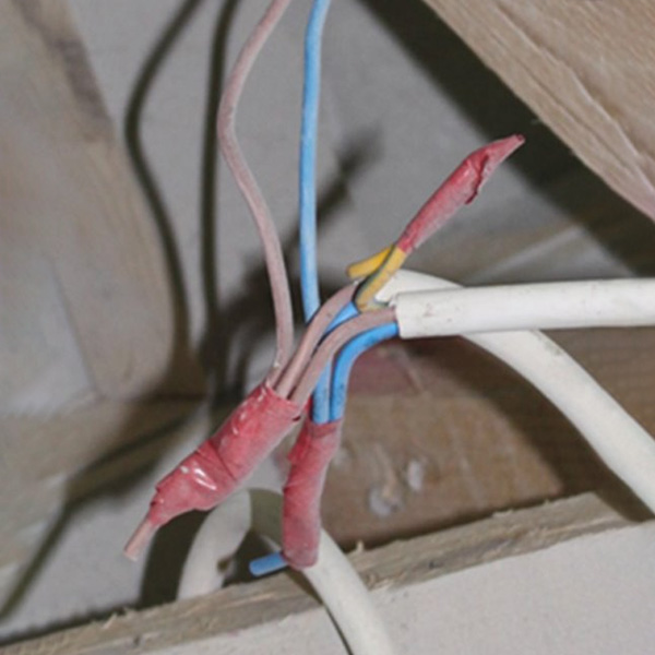 Electrical tape wrapped around wires displays improper connections on a live construction site