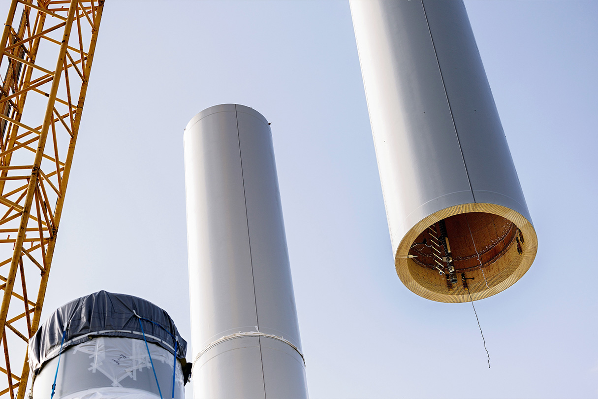 Wind turbine installation - a crane moving tower pieces into place